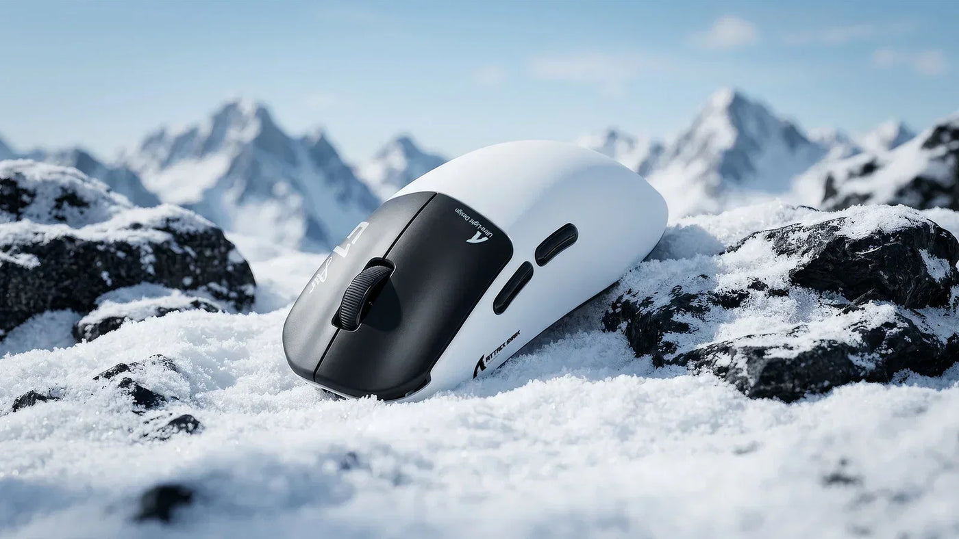 Attack Shark F1 Air wireless gaming mouse resting on snow‑covered rocks with snow mountain background